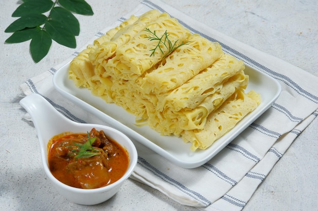 Roti Jala o frittella di pizzo o crepe di rete servite con curry di agnello o montone