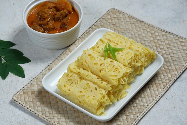 Roti Jala o frittella di pizzo o crepe di rete servite con curry di agnello o montone