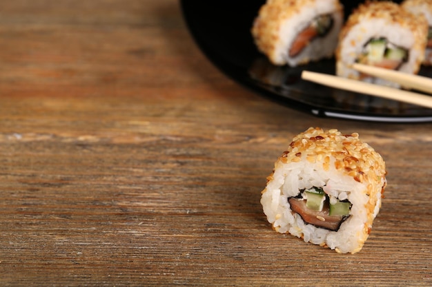 Rotoli con bastoncini sulla tavola di legno da vicino