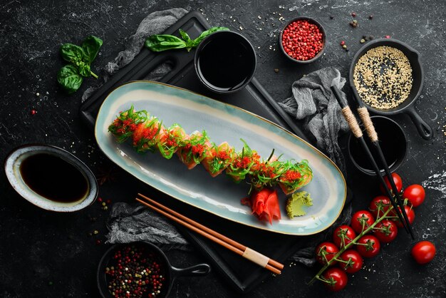 Rotoli con caviale di salmone e insalata di chuka su un piatto Sushi Vista dall'alto Stile rustico