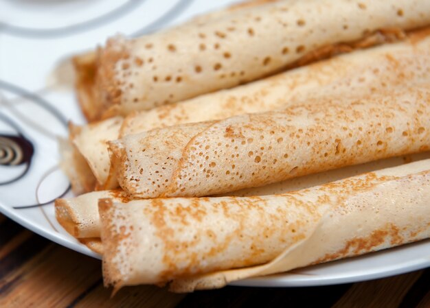 Rotoli deliziosi di crêpe sul piatto bianco