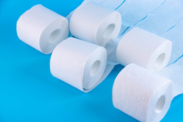 Rotoli di carta igienica bianca su sfondo blu con posto per testo, pubblicità.