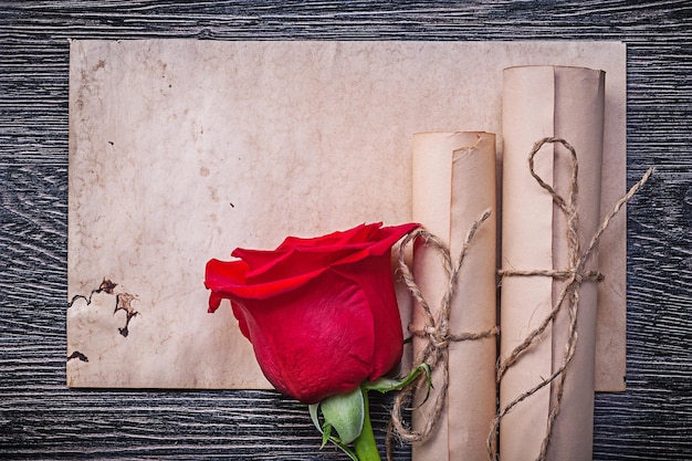 Rotoli di carta vintage rosa aromatica rossa su sfondo di legno