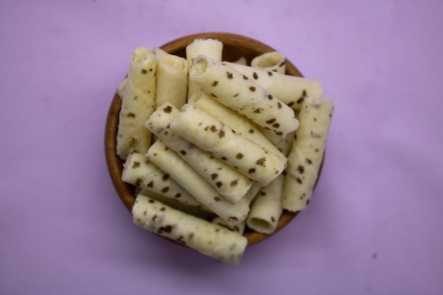 Rotoli di crema di cialda dolce alla vaniglia isolati su sfondo viola