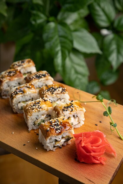 Rotoli di cucina giapponese con salsa su un piatto di legno