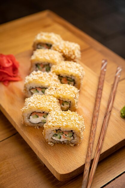 Rotoli di cucina giapponese con salsa su un piatto di legno