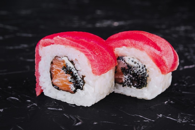 Rotoli di sushi con caviale nero di crema di formaggio e salmone con tonno