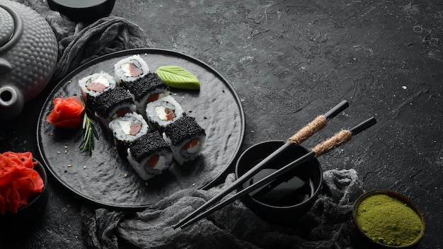Rotoli di sushi Fila Black con caviale nero salmone e formaggio Vista dall'alto Spazio libero per il testo