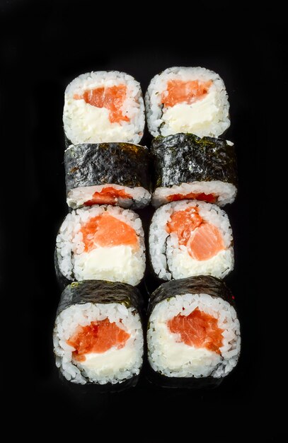 Rotoli di sushi giapponesi freschi tradizionali su un fondo nero