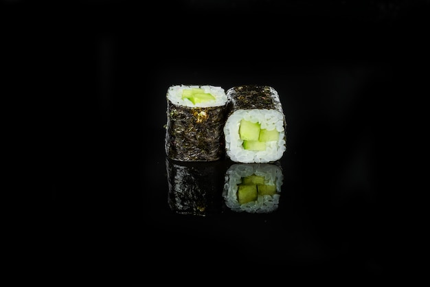 Rotoli di sushi giapponesi freschi tradizionali su un fondo nero