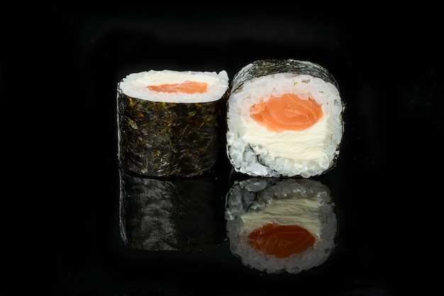 Rotoli di sushi giapponesi freschi tradizionali su un fondo nero