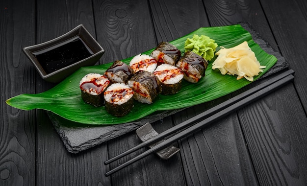 Rotoli di sushi maki con anguilla su sfondo nero