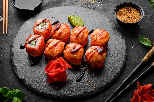 Rotoli di sushi tradizionali appetitosi su una lastra di pietra nera. Cucina giapponese. Vista dall'alto.