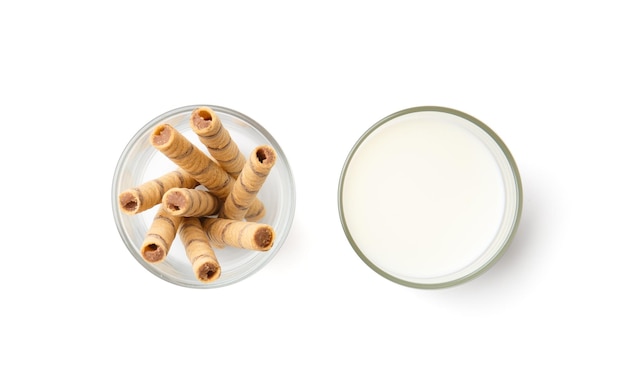Rotoli di wafer e un bicchiere di latte su uno spazio di copia con vista dall'alto su sfondo bianco