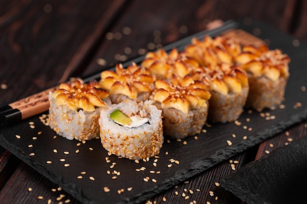 Rotolo con sushi di pesce con bacchette concetto di cibo asiatico