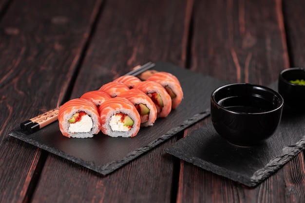 Rotolo con sushi di pesce con bacchette concetto di cibo asiatico