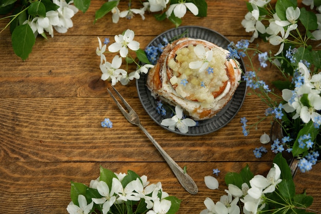 Rotolo di cannella e fiori della molla su fondo di legno