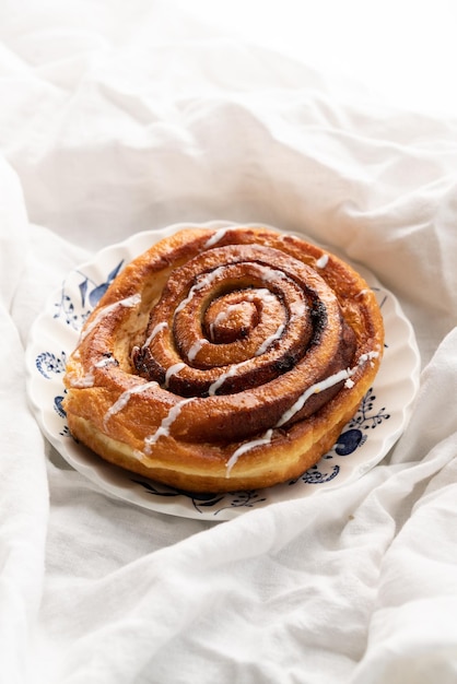 Rotolo di cannella su un piatto su un bianco