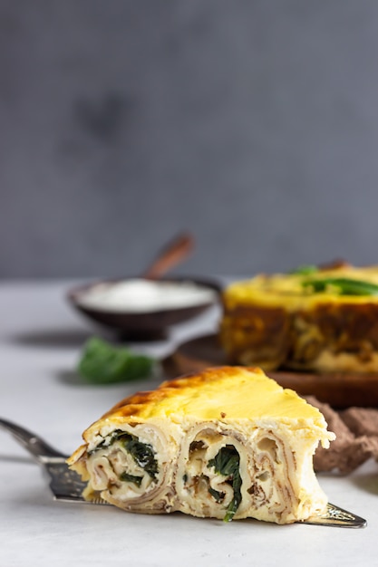 Rotolo di crepes con spinaci, pollo e crema di formaggio al forno con salsa besciamella