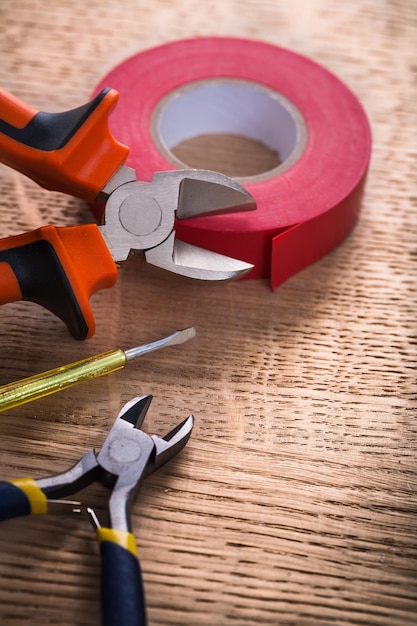 rotolo di due tronchesi di nastro isolante e tester sul concetto di costruzione di tavola di legno