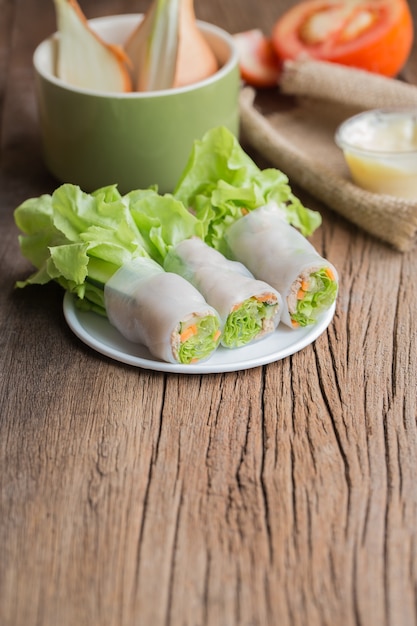 rotolo di insalata di tonno su piatti bianchi sul vecchio tavolo di legno.