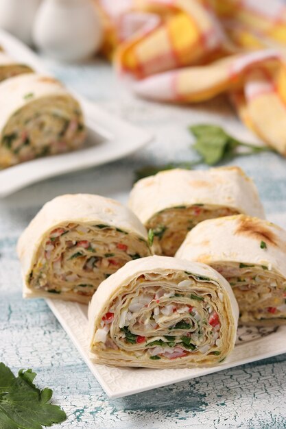 Rotolo di lavash con bastoncini di granchio e formaggio, uno spuntino festivo, primo piano