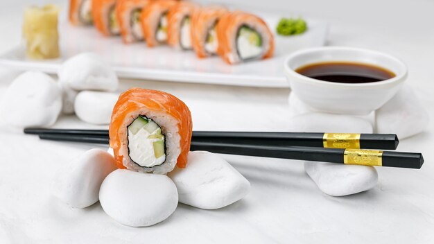 Rotolo di Philadelphia della cucina giapponese con salmone su un tavolo bianco