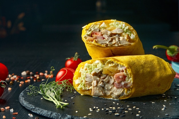 Rotolo di shawarma o burrito con lattuga, pollo e cetriolo in pita gialla. Cibo di strada. Copia spazio