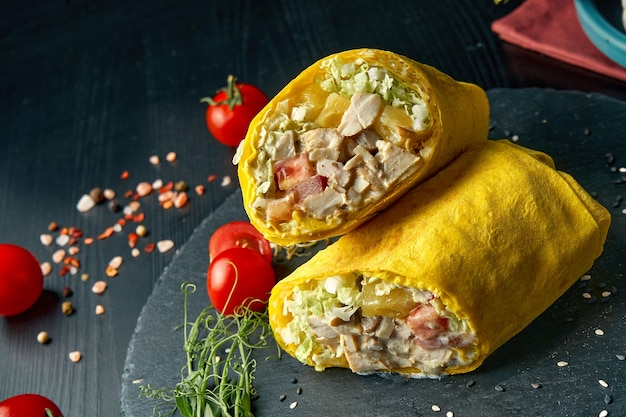 Rotolo di shawarma o burrito con pollo, ananas, pomodori e lattuga. cibo di strada