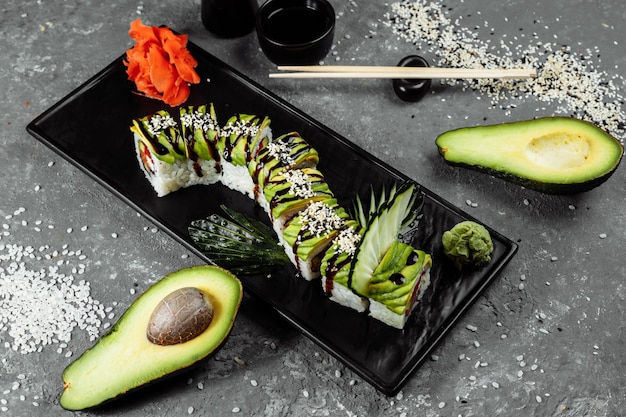Rotolo di sushi al drago verde con anguilla, avocado, cetriolo e zenzero, accompagnato da gamberi fritti in tempura