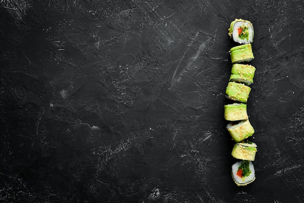 Rotolo di sushi con cetriolo avocado e pomodoro Cucina giapponese Vista dall'alto su sfondo nero