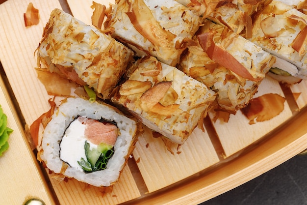 Rotolo di sushi con trucioli di tonno sulla fine del piatto su