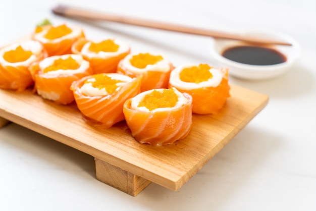 Rotolo di sushi di color salmone fresco con maionese e gamberi all'uovo