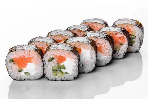 Rotolo di sushi fresco delizioso tradizionale impostato su uno sfondo bianco con la riflessione