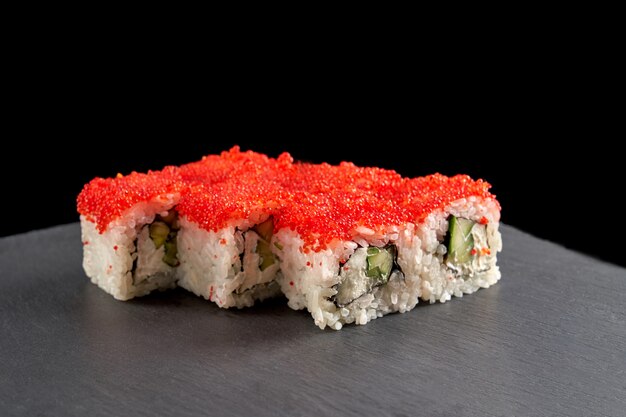 Rotolo di sushi giapponese coperto di uova di tobiko rosse.