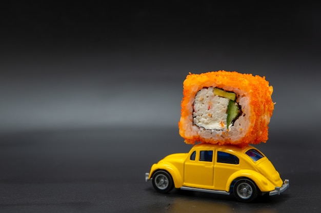 Rotolo di sushi in cima a una macchinina gialla