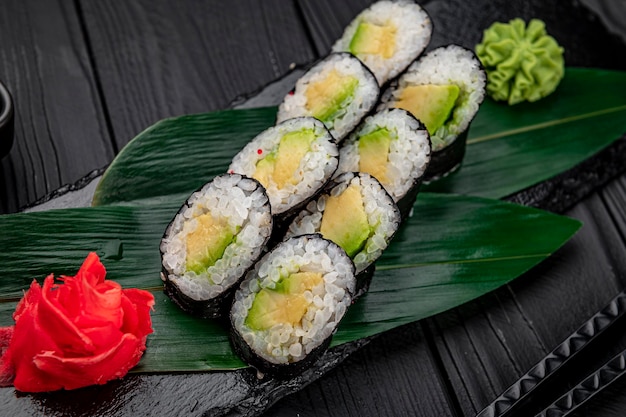 Rotolo di sushi maki appetitoso su una lastra di pietra nera