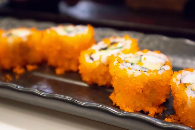 Rotolo di sushi maki californiano su piastra nera, cibo giapponese