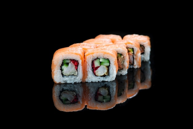 Rotolo di sushi su uno sfondo nero riflessione cibo giapponese da vicino