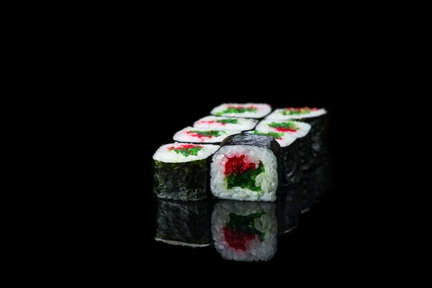 Rotolo di sushi su uno sfondo nero riflessione cibo giapponese da vicino