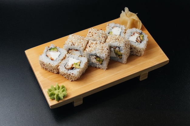 Rotolo di sushi tradizionale con anguilla e avocado su tavola di legno