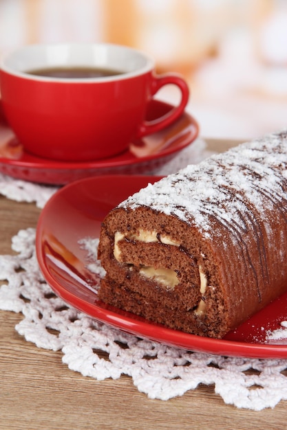 Rotolo dolce con una tazza di tè sul tavolo in cucina