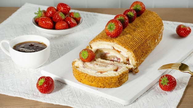 Rotolo dolce ripieno di fragola e panna decorato con fragole