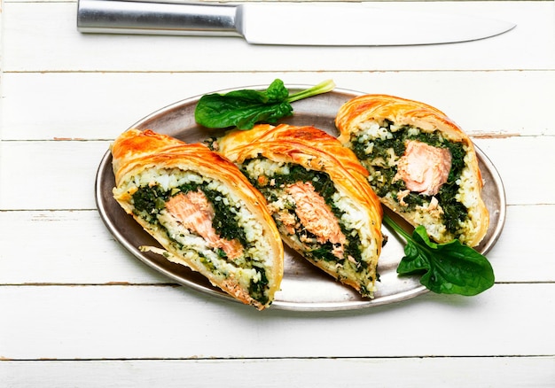 Rotolo gustoso con salmone, riso e spinaci. Torta di pesce. Pesce Wellington