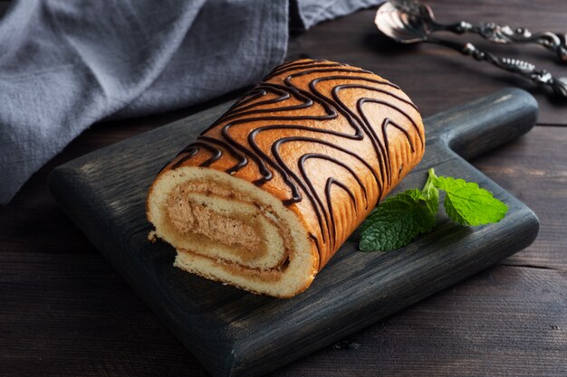 Rotolo in spugna dessert con crema al cioccolato e foglie di menta