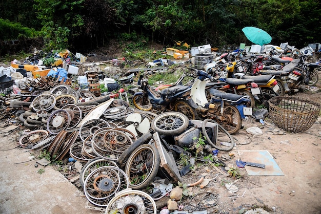 Rottami di rifiuti con la vecchia ruggine della motocicletta del motore, mucchio di vecchi cerchioni di metallo arrugginito nei rifiuti del veicolo della ruota del tamburo dell'auto