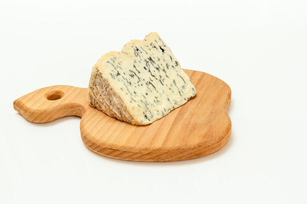 Rottura di Fourme d'Ambert, un formaggio blu francese semiduro su un tagliere di legno con la superficie bianca