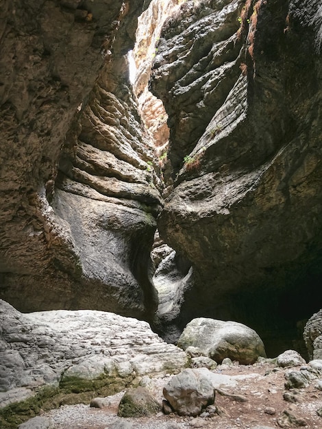 Rottura nella roccia, ingresso di una stretta grotta. Rocce interessanti che formano uno stretto passaggio nella gola di Saltinskij. Una riserva naturale unica in Daghestan. Gola nella natura del paesaggio delle montagne.