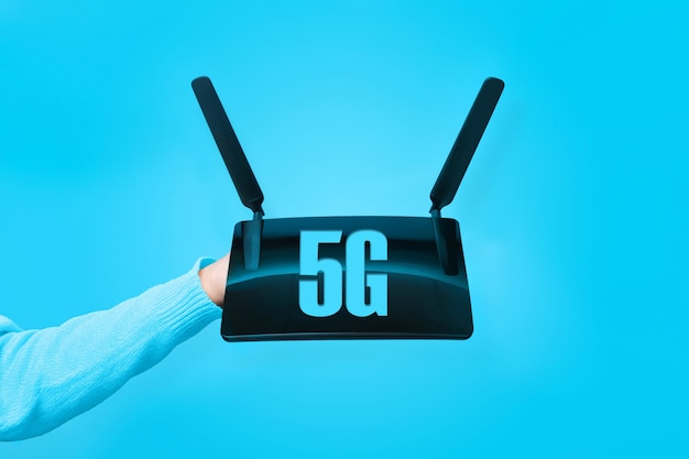 Router wifi nero a portata di mano e scritta 5G