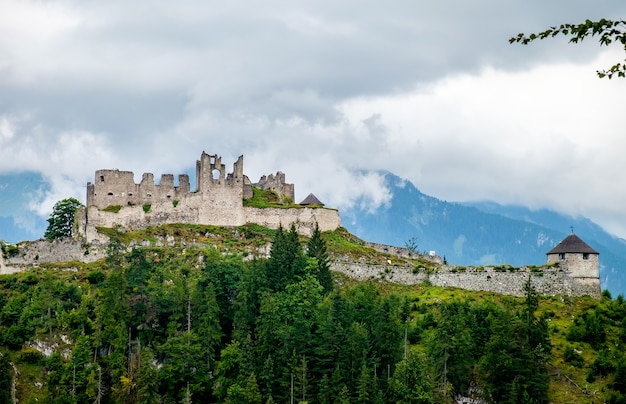 Rovine del castello nelle Alpi austriache in una giornata nuvolosa. Aspetto cinematografico vintage.